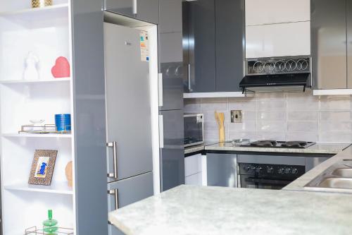 a kitchen with white cabinets and a white counter top at Stylish Self Catering Unit in Maseru CBD in Maseru