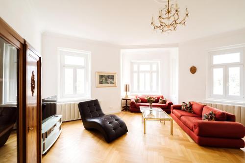 a living room with a red couch and chairs at Golf Apartment Villa Elisabeth in Mariánské Lázně