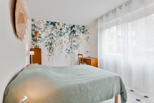 - une chambre avec un lit et un papier peint floral dans l'établissement T2 Cosy Jardin Port & Plage tout à pied, au Pouliguen