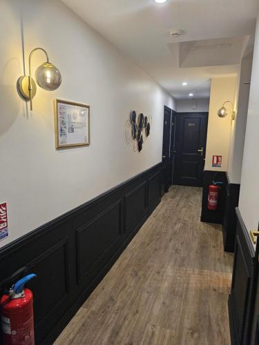 a long hallway with a white wall and a black door at La Caravelle in Aix-en-Provence