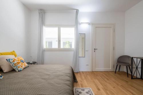 una camera da letto con un letto, una finestra e una sedia di Benjamin House - Exclusive Modern Loft a Bari