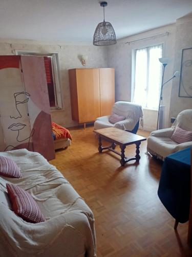 a living room with two beds and a couch and a table at Entre Bresse et Jura in Bellevesvre