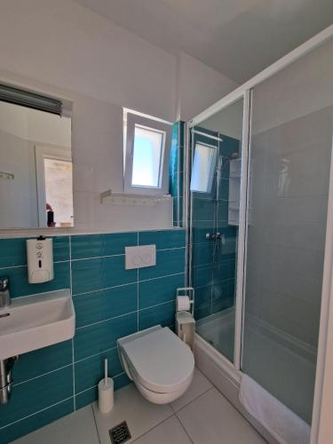 a bathroom with a toilet and a sink and a shower at Pension Augustino in Ražanac