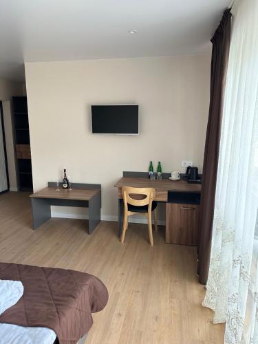 a bedroom with a desk and a table and a television at Guest House Zatyshnyi Dvir in Bukovel