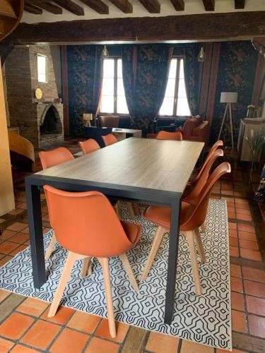 - une salle à manger avec une table et des chaises orange dans l'établissement Maison Saint Pierre, à Chartres