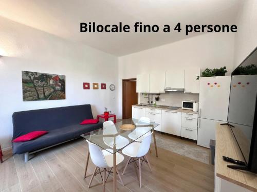 a living room with a blue couch and a glass table at La Casa di Leo Apartments in San Giorgio di Piano