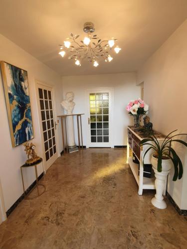 un salon avec une table et un lustre dans l'établissement Bruyère et Charmes de Bourgogne - Cluny Taizé Maison plain pied, à La Guiche