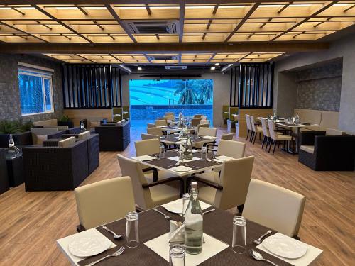 a restaurant with tables and chairs and a large screen at Hotel Sand Heaven in Port Blair
