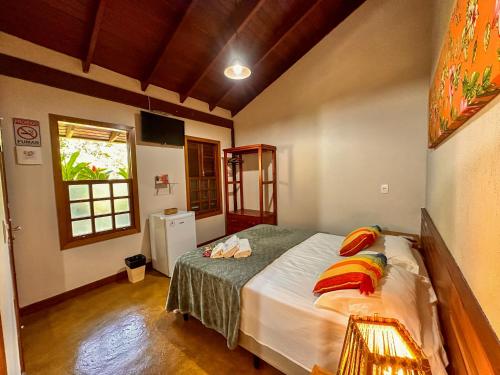 une chambre avec un lit et une fenêtre dans l'établissement Pousada Casa Zanotto, à Pirenópolis