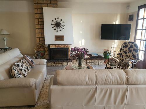 un salon avec un canapé et une cheminée dans l'établissement Bruyère et Charmes de Bourgogne - Cluny Taizé Maison plain pied, à La Guiche