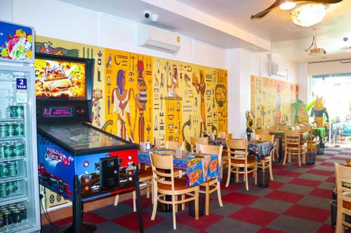 a restaurant with tables and chairs and a video game at Times Hotel at Bassac Lane in Phnom Penh