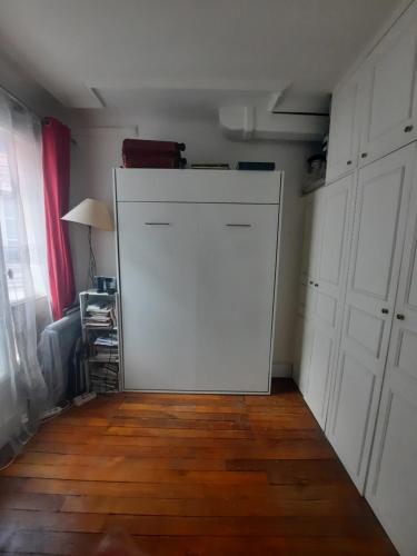 - une grande porte blanche dans une chambre dotée de parquet dans l'établissement Appartement familial dans le 16é, à Paris