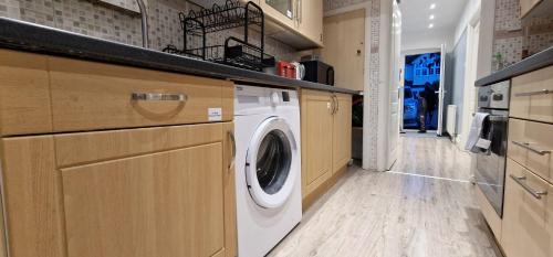 a laundry room with a washer and dryer at Rowan Crescent's Luxury Stay-In 3 in Streatham Vale