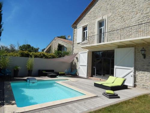 une piscine devant une maison dans l'établissement Spacieuse maison de village avec piscine, à Saint-Mathieu-de-Tréviers
