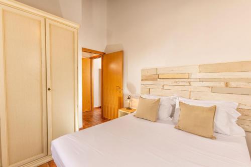 Un dormitorio con una cama blanca con dos almohadas. en Amazing apartment with swimming pool, Montepulciano Toscana, en Montepulciano