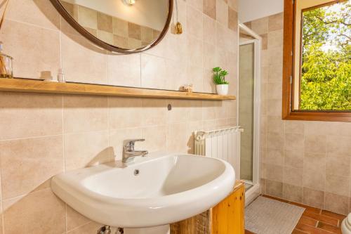 un baño con lavabo y espejo en Amazing apartment with swimming pool, Montepulciano Toscana, en Montepulciano