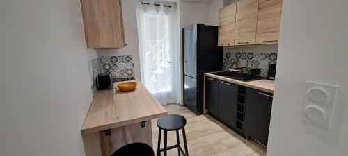 - une petite cuisine avec un comptoir et un tabouret dans l'établissement Charmant studio neuf Ajaccio Casone - Trottel, à Ajaccio