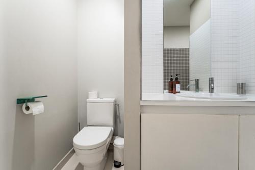 a white bathroom with a toilet and a sink at Appartement T3 de Prestige proche du Jardin Public de Bordeaux in Bordeaux