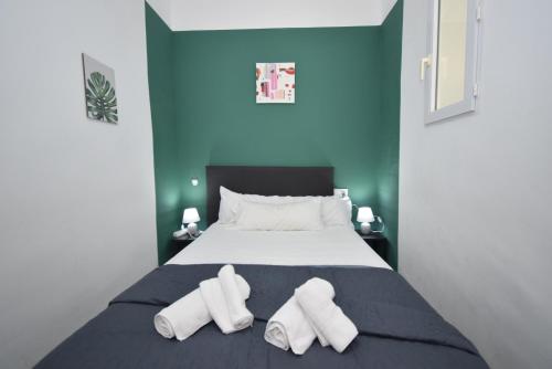 una camera da letto con un letto e due pantofole bianche di LA SIESTA I-14 - Fincas Arena a Benidorm