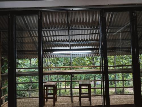 a room with two chairs and a large window at The Forest - Sell the Experience in Pai