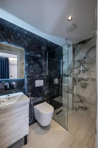 a bathroom with a toilet and a sink and a shower at Hotel Vila Melina in Ksamil