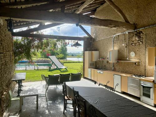 - une cuisine avec une table, des chaises et une table dans l'établissement Ferme rénovée 6 chambres, vue sur lac et piscine, à Castet-Arrouy