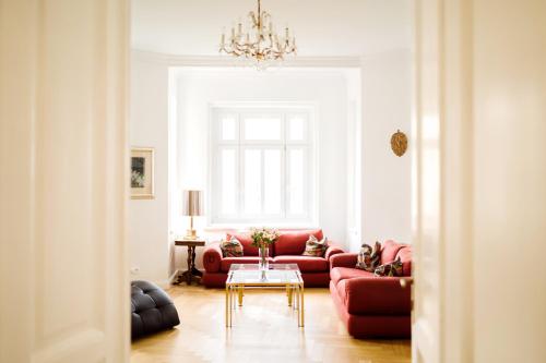 a living room with a red couch and a table at Golf Apartment Villa Elisabeth in Mariánské Lázně