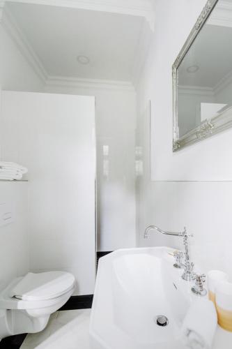 a white bathroom with a tub and a toilet at Golf Apartment Villa Elisabeth in Mariánské Lázně