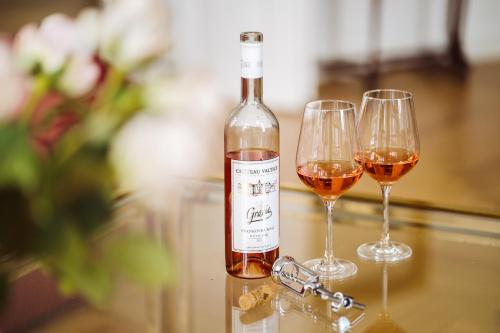 a bottle of wine and two glasses on a table at Golf Apartment Villa Elisabeth in Mariánské Lázně