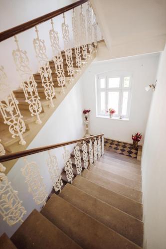 a staircase in a house with white walls and a window at Golf Apartment Villa Elisabeth in Mariánské Lázně