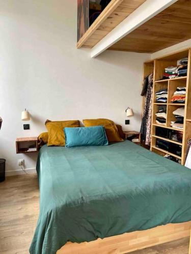 une chambre avec un lit avec des oreillers bleus et jaunes dans l'établissement Un petit cocon en plein cœur du 11eme, à Paris