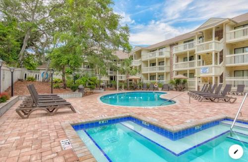 a swimming pool in front of a apartment building at Elegant Coastal Getaway Spacious 3BR Chelsea House in Myrtle Beach