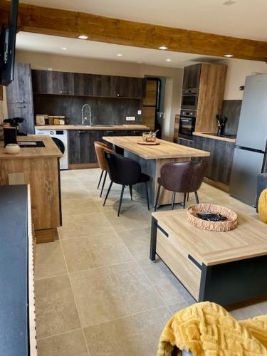 Il comprend une cuisine équipée de tables, de chaises et d'un réfrigérateur. dans l'établissement La petite maison de Marie, à Saint-Pierre-en-Port