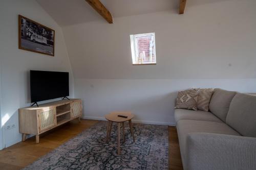 a living room with a couch and a television at Boven appartement Noard in Workum