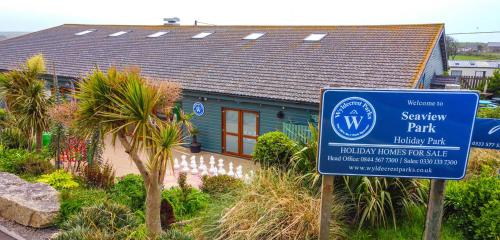 a blue house with a sign in front of it at Seaview Holiday Park in Penzance