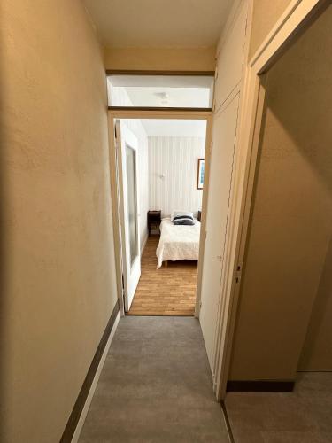 a hallway leading to a bedroom with a bed at Résidence Les Milandes in Cazaubon