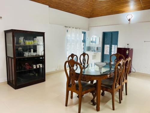 une salle à manger avec une table et des chaises en bois dans l'établissement Kuttanad Kaya'k Club Villa, à Alappuzha