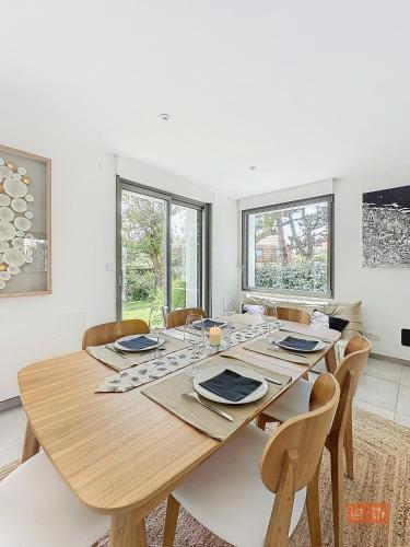 une salle à manger avec une table et des chaises en bois dans l'établissement Les Pins : Rez de jardin proche plage, à Ambleteuse