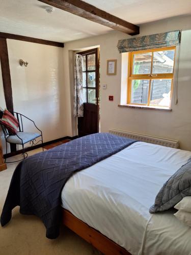 a bedroom with a large bed and a window at George & Dragon Country Pub & Hotel Wolverton Townsend in Tadley