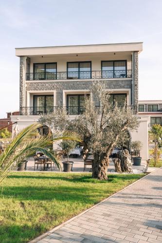 a building with a palm tree in front of it at CAROLEA VILLAS in Ulcinj