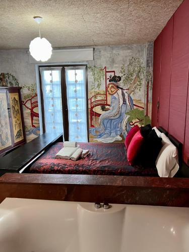 a bed in a room with a painting on the wall at Posada la Leyenda in Santillana del Mar