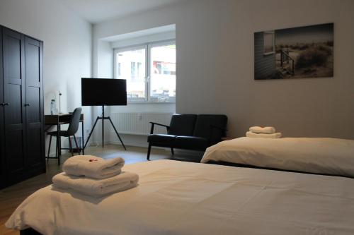 a bedroom with two beds and a chair and a desk at Großzügiges Zimmer im Zentrum mit 2 Betten in Paderborn