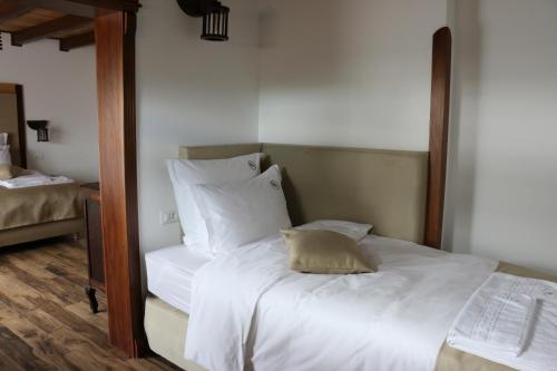 a bedroom with a white bed with a mirror at Domeniul Mortasifu in Nişcov