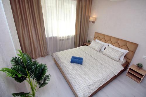a bedroom with a large bed with a blue pillow on it at Almaty Cozy Apart Hotel in Almaty
