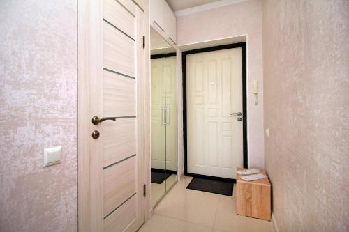a corridor with a door and a stool in a room at Almaty Cozy Apart Hotel in Almaty