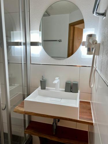 a bathroom with a white sink and a mirror at Gasthof Löwen in Pfronten