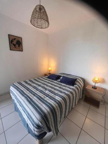 - une chambre avec un lit et deux lampes sur deux tables dans l'établissement Les pieds dans l'eau, à San-Nicolao