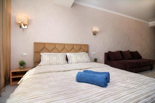 a bedroom with a large bed with a blue object on it at Almaty Cozy Apart Hotel in Almaty