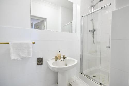 a white bathroom with a sink and a shower at Northop Hall Country House Hotel in Mold