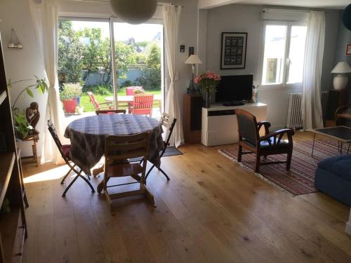 un salon avec une table, des chaises et un canapé dans l'établissement Jolie Maison proche plage Sables Blancs, à Concarneau
